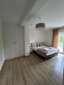 ŻarkiRezydencja Leśniów的白色的卧室设有床和大窗户