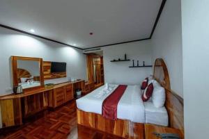 武里南Sky View Hotel Buriram的一间卧室配有一张床、一个梳妆台和镜子