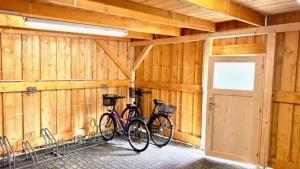 布尔格KrabatResidenz - Apartmenthaus的两辆自行车停放在木制车库内