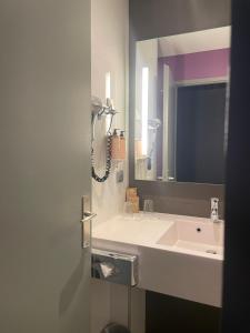 格勒诺布尔格勒诺布尔中心酒店美居酒店的一间带水槽和镜子的浴室