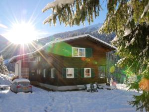 茵聂科里姆斯Beautiful and very luxurious chalet in walking and skiing area Innerkrems的雪中的房子,太阳在后面