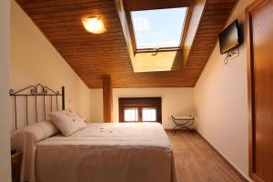 坎德莱达耶希旅舍的一间卧室配有一张床和天窗