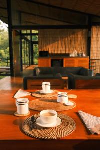 KalawanaKurunduketiya Private Rainforest Resort的上面有杯子和盘子的桌子