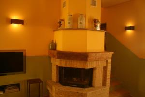 Colle San LorenzoAntico Casale San Lorenzo的客厅设有石制壁炉和电视