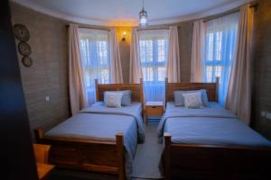 LemiraBoloti Camp resort的带2扇窗户的客房内的2张床