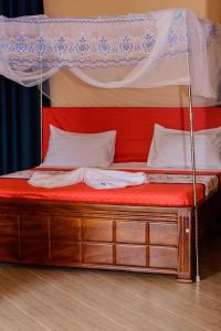KihihiNB MOTEL-KIHIHI的一张带红色床垫的天蓬床