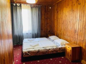 Wola PrzypkowskaGreen House的卧室配有木墙内的一张床