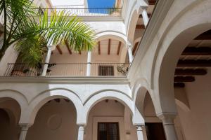 塞维利亚Casa del Rey Sabio的一座拱门建筑和一座棕榈树建筑