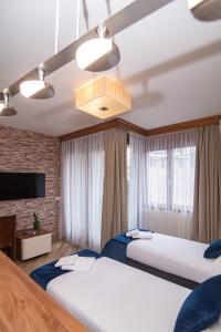 兹拉蒂博尔Central Inn的酒店客房设有两张床和吊灯。