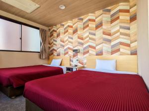 福冈新盖亚官酒店的酒店客房,配有两张带红色床单的床