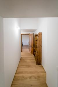 格罗塞托Agriturismo Bio San Mamiliano的走廊通往带白色墙壁和木地板的客房