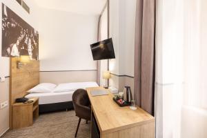 布达佩斯城市之环酒店的酒店客房配有一张床和一张带电脑的书桌