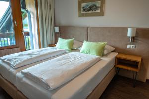 萨尔茨堡Hotel Haus Arenberg的一间卧室配有一张带绿色枕头的大床