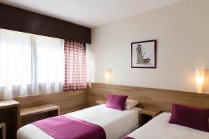 BeaupréauThe Originals City, Le Logis d'Elbée, Cholet Nord (Inter-Hotel)的两张位于酒店客房的床铺,配有紫色枕头