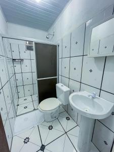 伦索伊斯Pousada Sempre Viva Lençóis的白色的浴室设有卫生间和水槽。