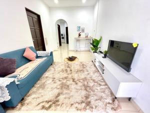 大山脚Cozy 288 Entire 3 bedroom House @ Alma Bukit Mertajam的客厅配有蓝色的沙发和平面电视。