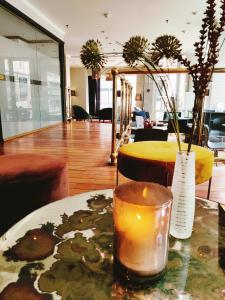 奥斯陆奥斯陆第一千禧酒店的房间里的桌子上有一个蜡烛和一个花瓶