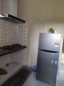 阿罗士打ABHAR Inap Desa的厨房配有不锈钢冰箱和炉灶。