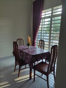 阿罗士打ABHAR Inap Desa的餐桌、四把椅子和窗户