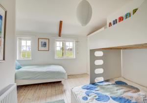Little BarninghamAurora Cottage的儿童卧室配有双层床和窗户