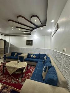 伊尔比德شقة مفروشة للايجار的客厅配有蓝色的沙发和桌子