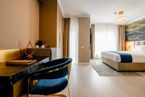 ChiajnaElitte Inn & Suites的配有一张床和一张书桌的酒店客房