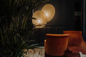 巴黎Maison Urbaine的一间设有两把橙色椅子和一盏灯的房间