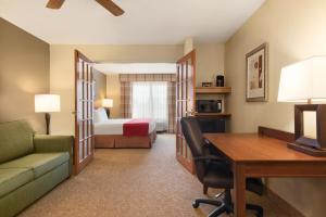 达文波特乡村酒店及套房由卡尔森 - 达文波特管理的酒店客房配有书桌和床。