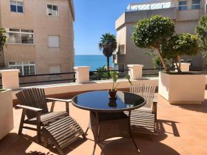 贝纳尔马德纳Siriana Suites 101, 001的一个带桌椅的庭院和大海