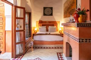 马拉喀什阿利利摩洛哥传统庭院的一间卧室配有一张床和一个壁炉