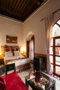 马拉喀什阿利利摩洛哥传统庭院的一间卧室配有一张特大号床和一个壁炉