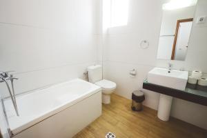 奥赫里德AMMOTTI Hotel and Apartments的带浴缸、卫生间和盥洗盆的浴室