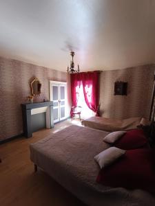 DescartesDescartes的一间卧室配有两张带红色窗帘的床和壁炉