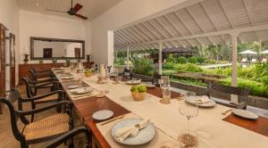 尼甘布Uga Riva - Negombo的用餐室配有长桌子、椅子和镜子