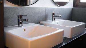 因斯布鲁克Eva Apartments - Bergisel的一间带白色水槽和2个水龙头的浴室