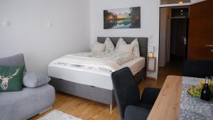 因斯布鲁克Eva Apartments - Bergisel的一间卧室配有一张床、一张沙发和一张桌子