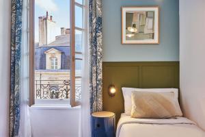 波尔多Hôtel Bordeaux Clémenceau by Happyculture的一间卧室设有一张床和一个窗口