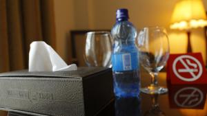 亚的斯亚贝巴Wassamar Hotel的桌子上摆放着一瓶水,带眼镜
