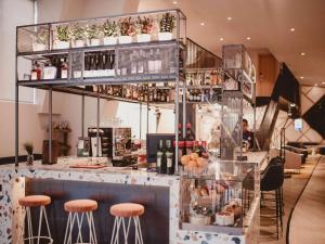 塞维利亚Novotel Sevilla的餐厅设有酒吧,提供凳子和葡萄酒