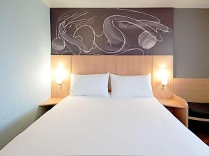 巴塞罗那宜必思巴塞罗那玛瑞迪那酒店的一间卧室配有一张带两个白色枕头的大床