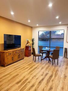 奥克兰Brand New & Central - 3 Bedrooms with 3 En suites的客厅配有桌子和平面电视。
