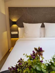 巴塞罗那Hotel Casa Gardenia的一张铺有白色床单和紫色花卉的床