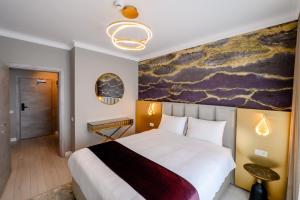 ChiajnaElitte Inn & Suites的卧室配有一张大床,墙上挂有绘画作品