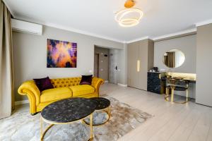 ChiajnaElitte Inn & Suites的客厅配有黄色的沙发和桌子