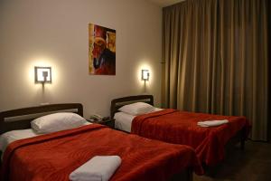 杰津鸢尾花酒店的酒店客房,配有两张带红色床单的床