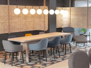 布鲁瓦布卢瓦市中心卢瓦尔河谷诺富特酒店的一间会议室,配有木桌和椅子