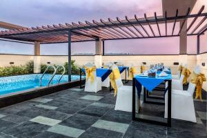 古瓦哈提Hotel Palacio的一间设有蓝色桌椅的餐厅和一个游泳池