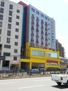 亚的斯亚贝巴Wassamar Hotel的街道旁的黄色外墙大建筑