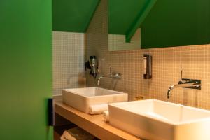 胡塔伦德巴里亚酒店的浴室设有两个水槽和绿色的墙壁。