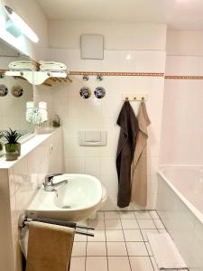 奥伯斯特多夫Haus Am Mühlbach - SommerBergBahn unlimited kostenlos的浴室配有盥洗盆和浴缸。